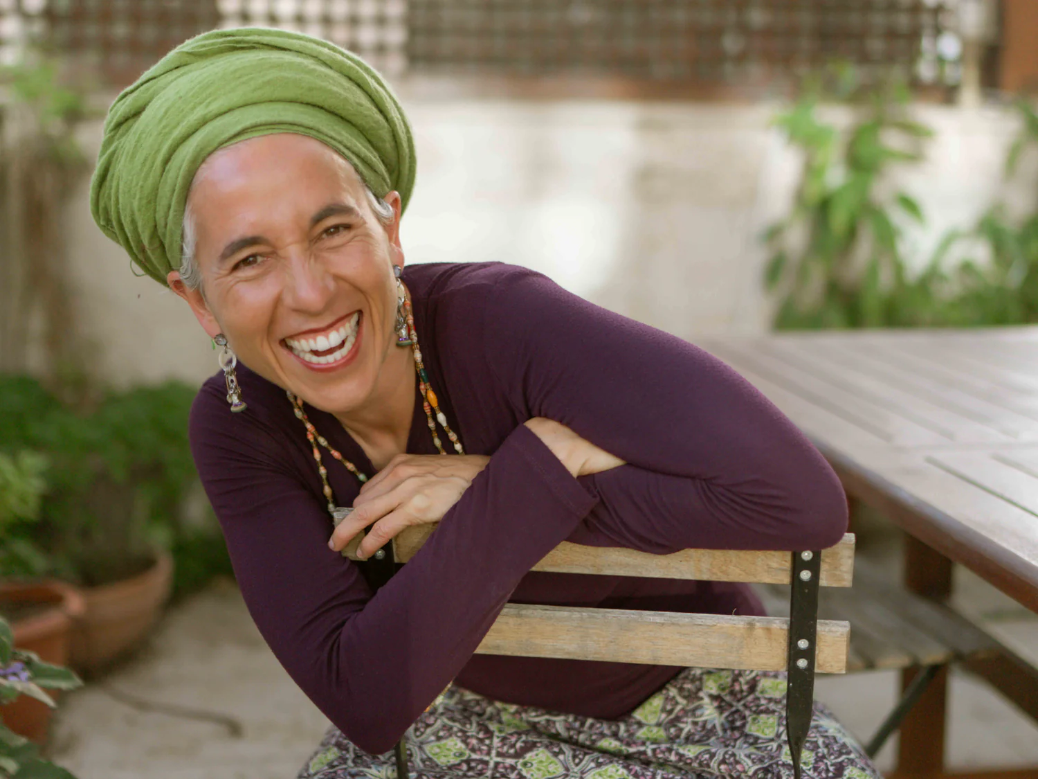 Chana Mason laughing, leaning on the back of a chair